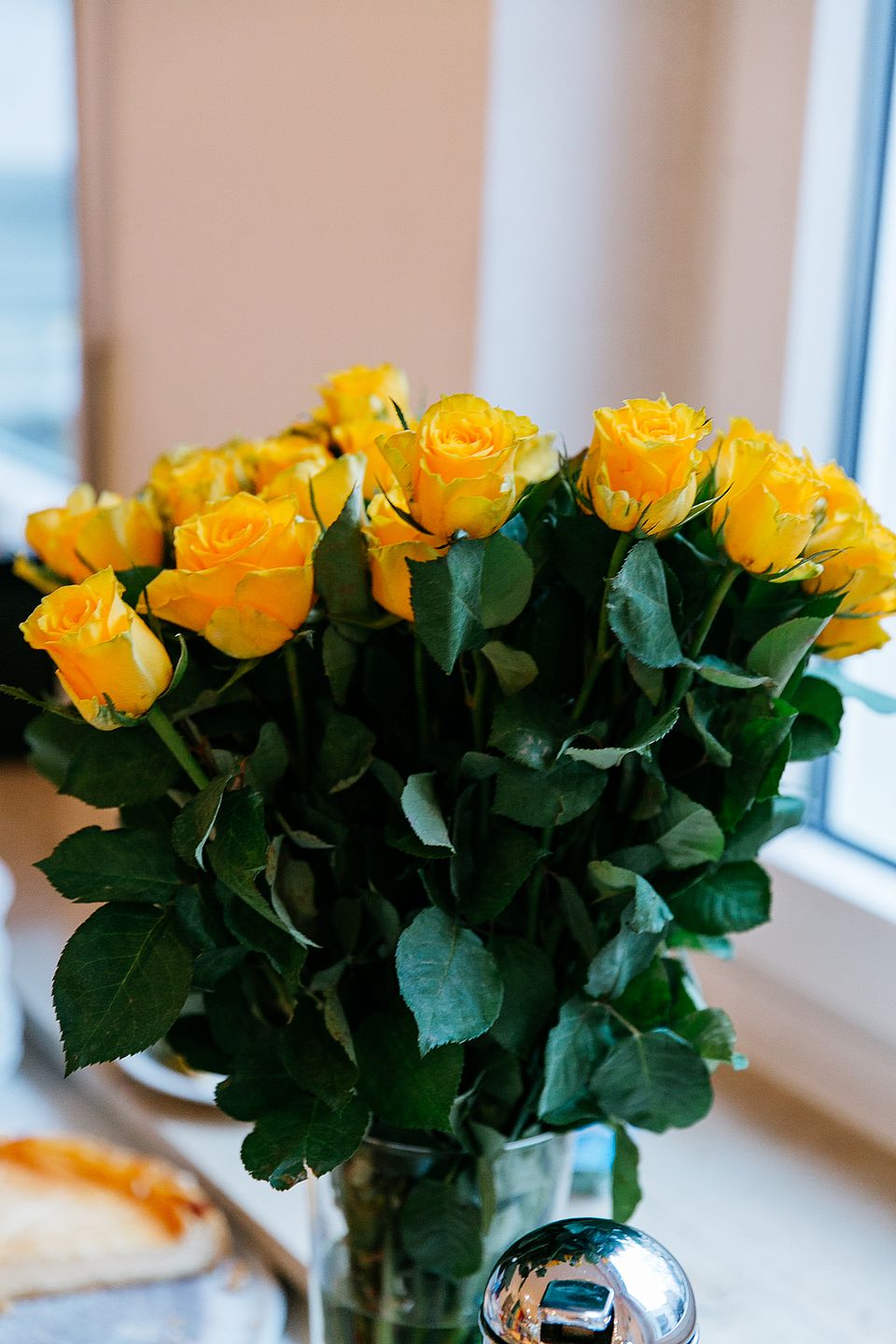 Ein Strauß gelber Rosen in einer Vase.